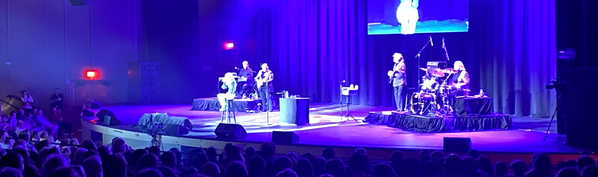 signer on stage in chair washed out by the lights Cedar Rapids